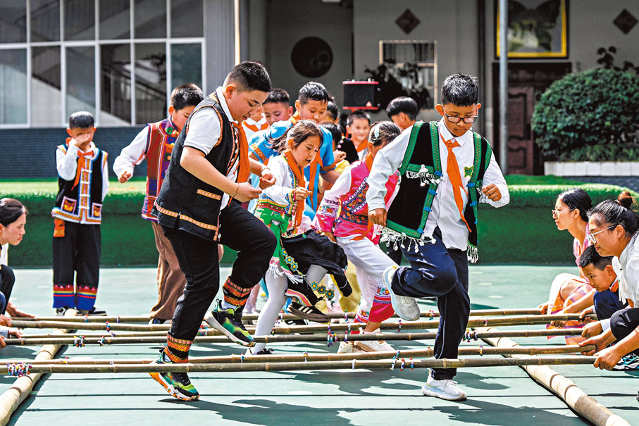 ◆學生在操場上跳竹竿舞。新華社