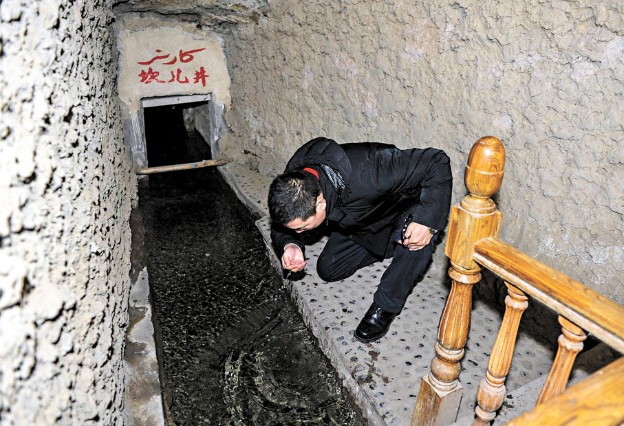 ◆坎兒井隱藏於地下，水量蒸發損耗極小。圖為遊客捧起清澈的坎兒井水品嘗。 資料圖片