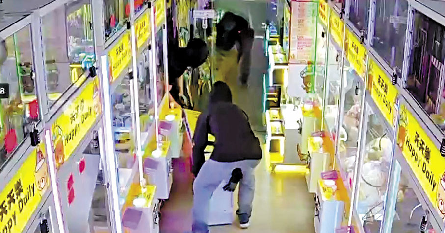 ◆賊人合力抬走兌換機。 影片截圖