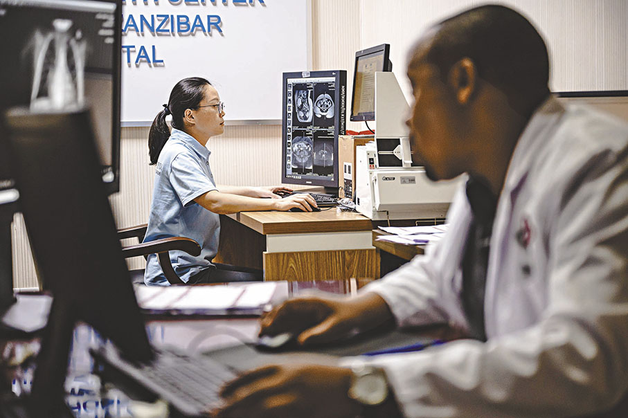 ◆2023年12月29日中國援桑給巴爾醫療隊影像科醫生田彤彤（左）在坦桑尼亞桑給巴爾的納茲莫加醫院查看核磁共振影像。 資料圖片