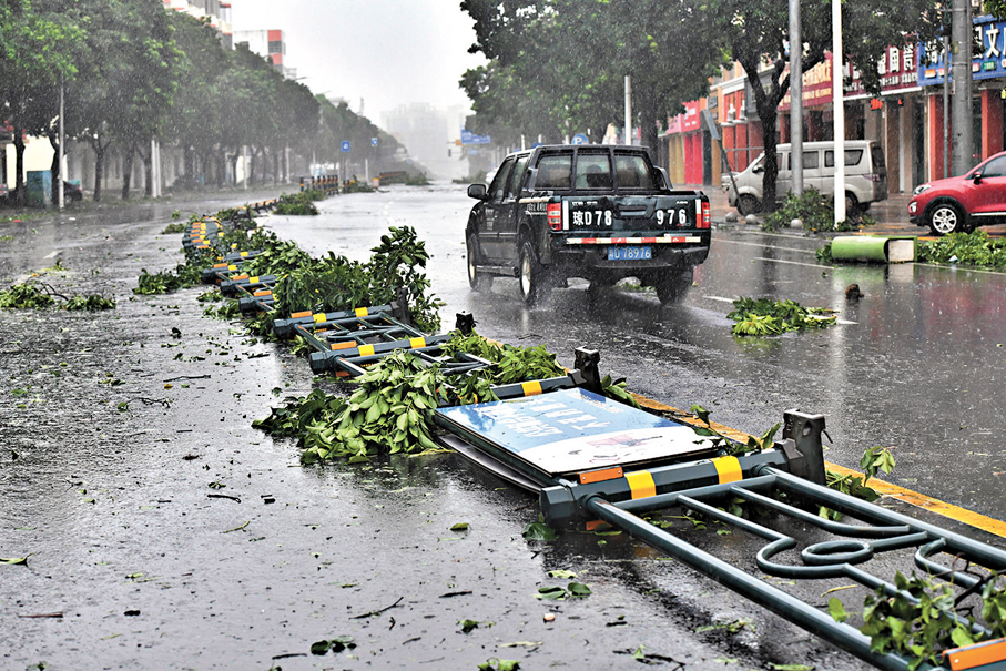 ◆「摩羯」肆虐，先後登陸文昌和徐聞。圖為9月6日，海南文昌，道路護欄被大風吹倒。 中新社