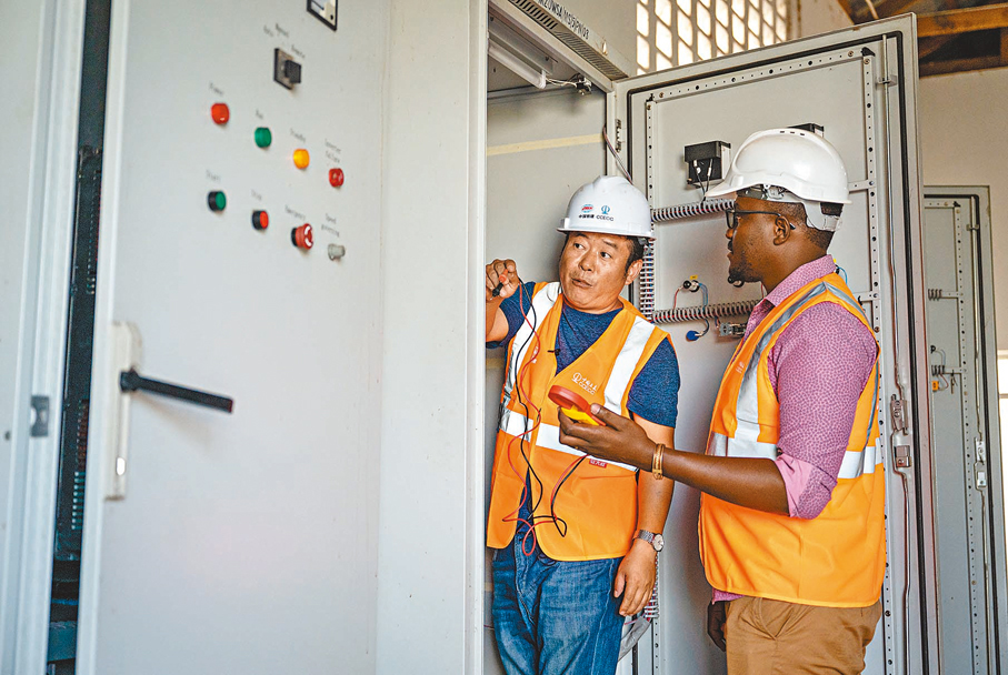 ◆ 截至2022年底，3,000多家中國企業在非洲投資興業。圖為在坦桑尼亞姆萬扎省米松圭新水廠，中國工人和非洲同事進行電路檢測工作。 資料圖片