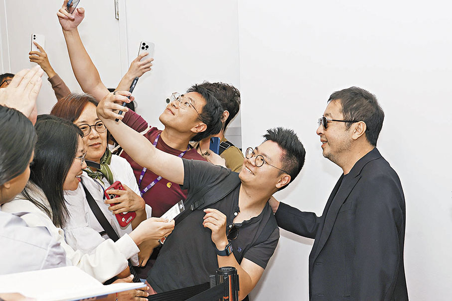◆賈樟柯亮相紅地毯時,與影迷合影。 中新社