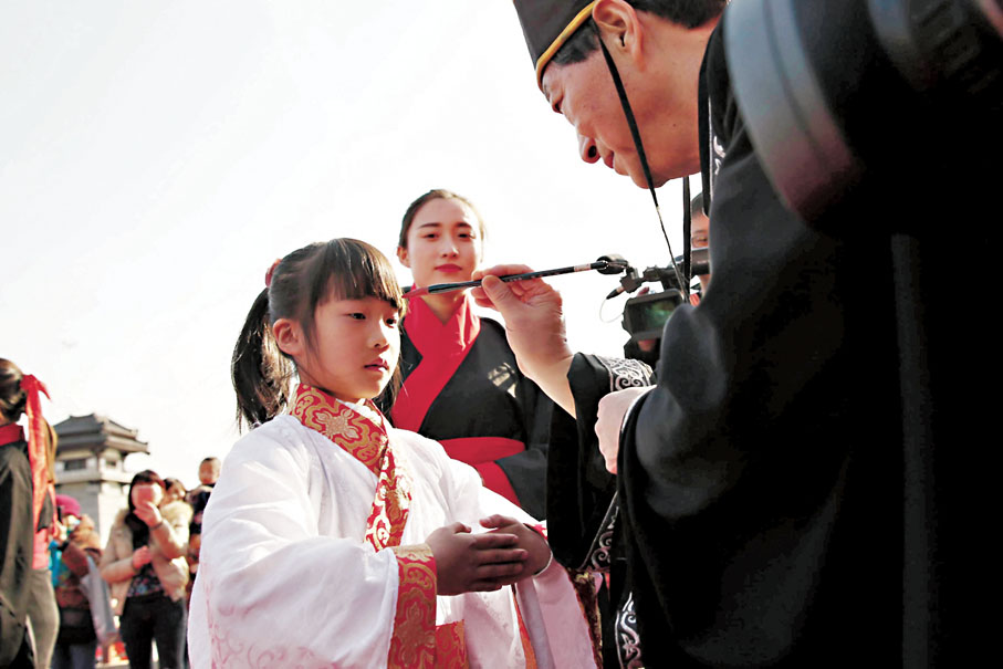 ● 西安開筆禮活動，老師用朱砂筆為學童「開智」。 資料圖片