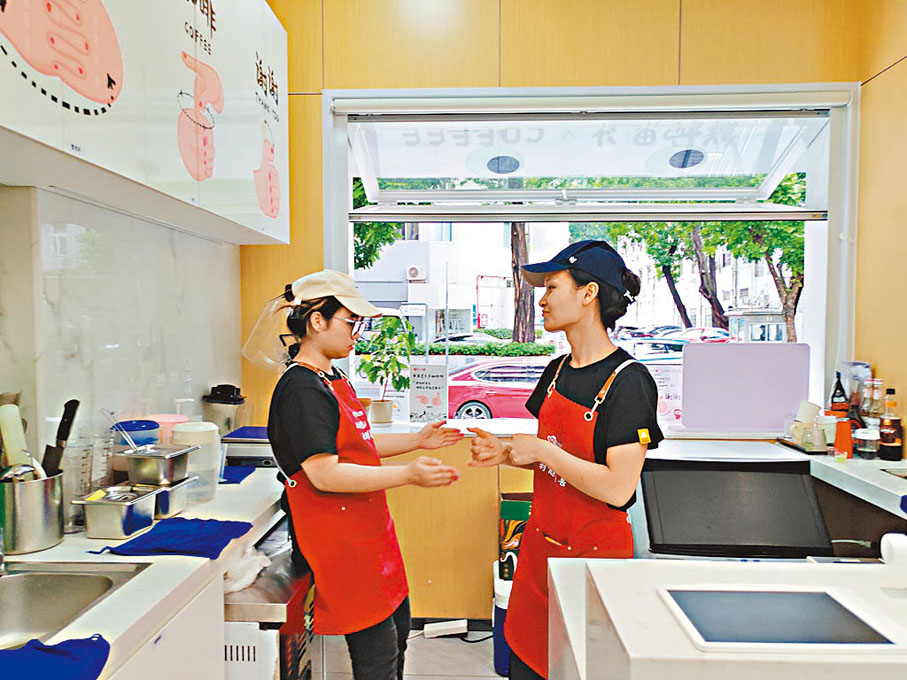●店員小危（右）與同事用手語交流。