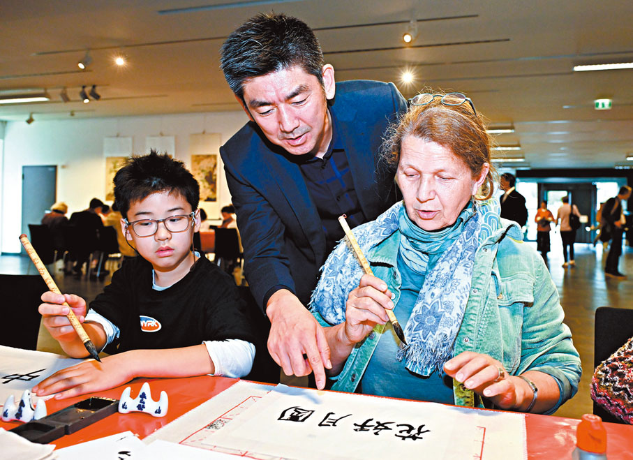 ●9月14日，德國柏林中國文化中心，一名女士在慶祝的中秋節活動中學習中國書法。新華社