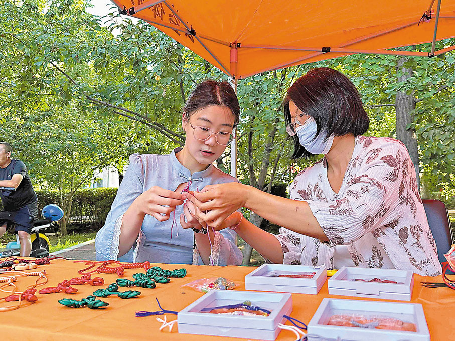 ●旗袍文化周期間，一位青年女性身着旗袍在瀋陽市和平區旗袍文化創意市集上學習傳統手工盤扣技藝。