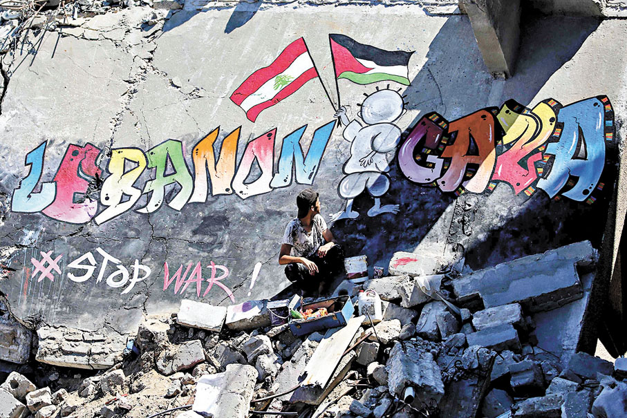 ●一名巴男子在加沙一棟被毀房屋上繪畫壁畫，聲援黎巴嫩人民。 法新社