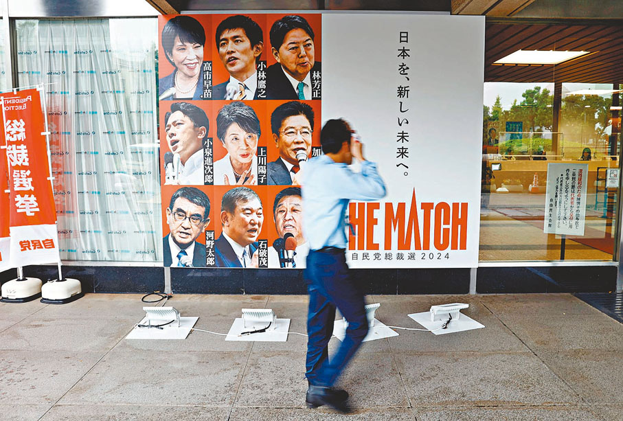 ●日本東京自民黨總部門前，展示候選人海報。路透社