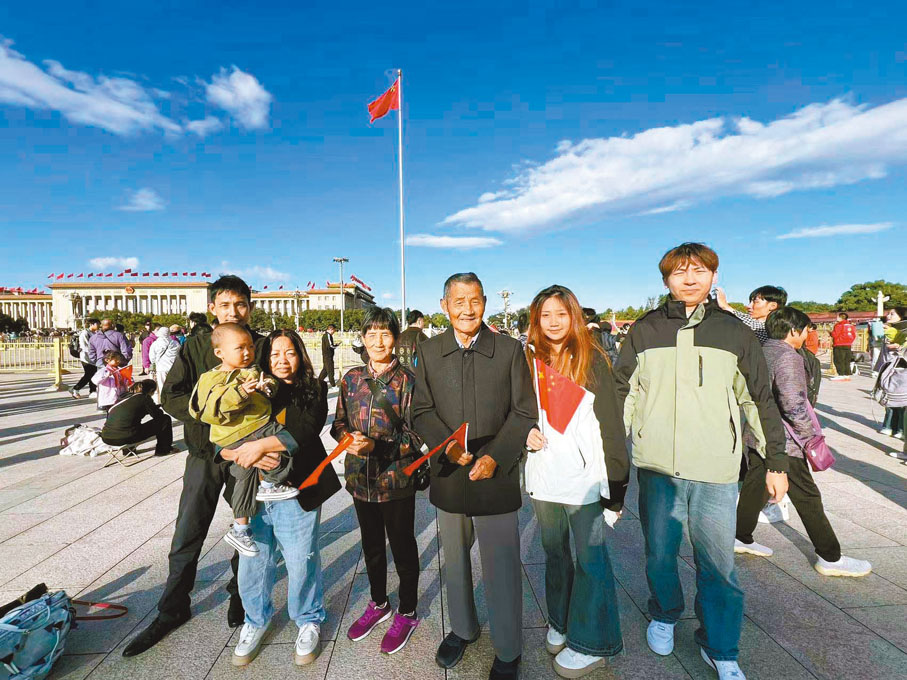 ●浙江的溫氏家族祖孫四代七口人在天安門廣場國旗下合影留念。 香港文匯報記者郭瀚林  攝