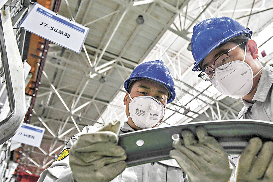 ●2022年12月14日一汽解放汽車有限公司卡車廠衝壓車間，馮斌（左）與同事王金生研究改進生產工藝。 資料圖片