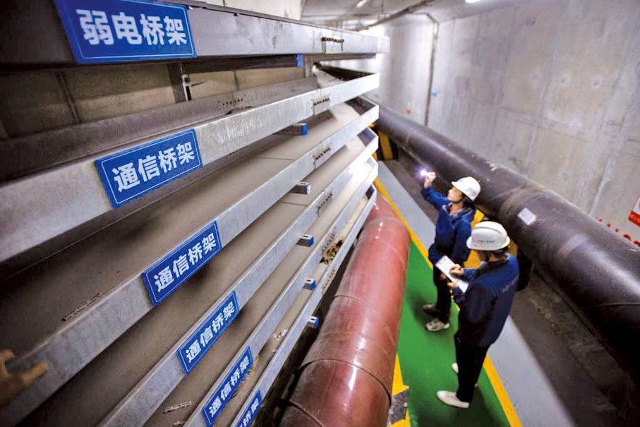 ● 地下綜合管廊建設和運維是城市更新的重要基礎工作。城市地下綜合管廊用於集中敷設電力、通信、廣播電視、給水、排水、熱力、燃氣等多種市政管線的公共地下空間，並預留檢修空間，有效緩解「馬路拉鏈」「空中蜘蛛網」等城市病。　圖為2023年5月12日，運維人員在湖北十堰紫霄大道管廊內巡檢管線橋架。 （新華社）