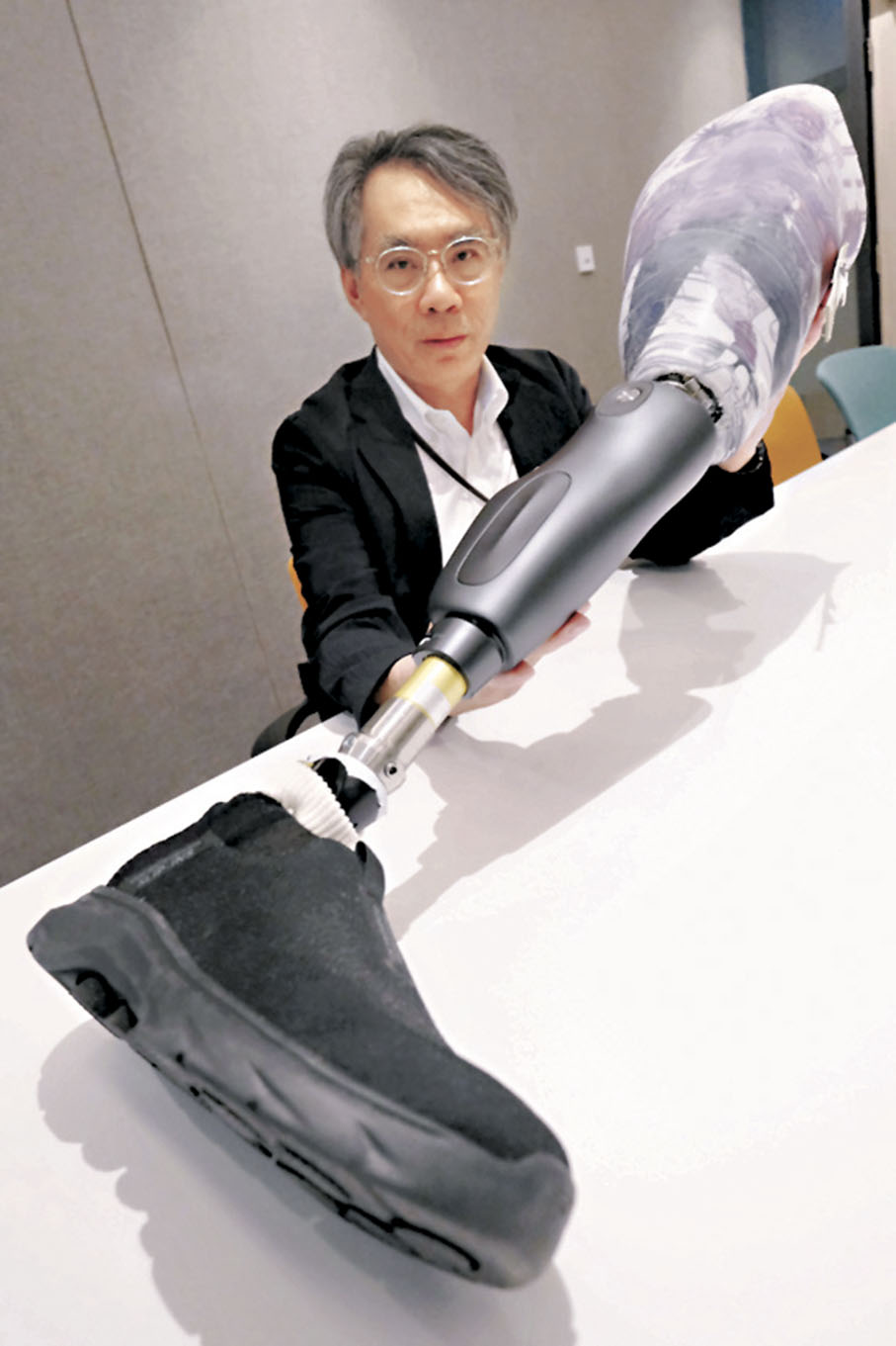 ●羅尚尉醫生展示內地研發的電動假肢，性能不但先進，更遠較外國品牌便宜。 香港文匯報記者涂穴  攝