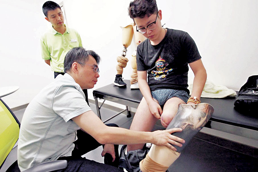 ●由於截肢人士體型會有變化，假肢亦會磨損，羅尚尉（左）至今仍會北上為病人更換假肢。