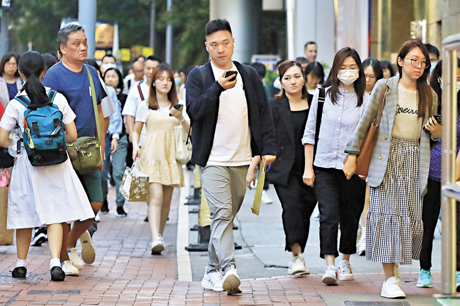 ●香港天氣漸漸轉涼，料未來一周最低氣溫26度左右，「寒露」和「霜降」後繼續降溫。圖為市民遊客穿上外套行街。 香港文匯報記者北山彥 攝