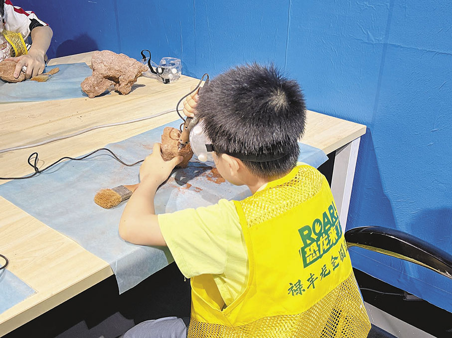 ●小孩體驗恐龍化石修復。 香港文匯報昆明傳真