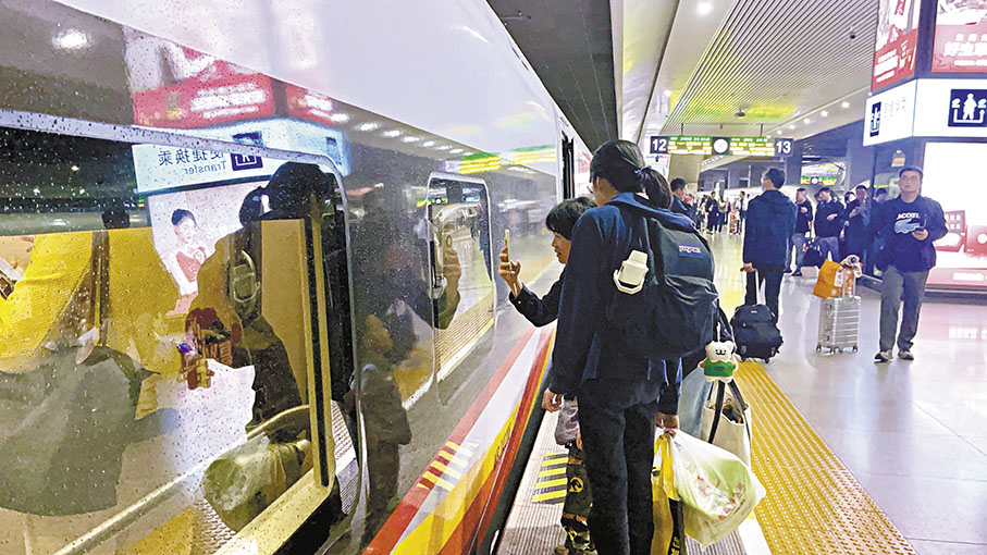 ●從對面站台下車的旅客看到全新滬港「復興號」智能型動臥列車後，特意湊近一探究竟。 香港文匯報 記者夏微  攝