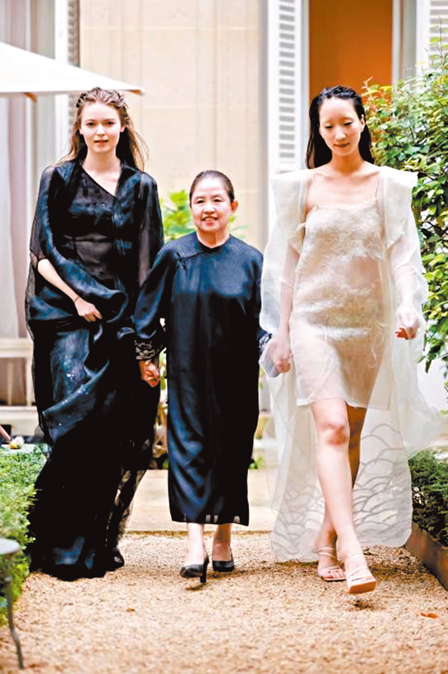 ●李薇（中）在SS2025巴黎時裝周與模特合照。