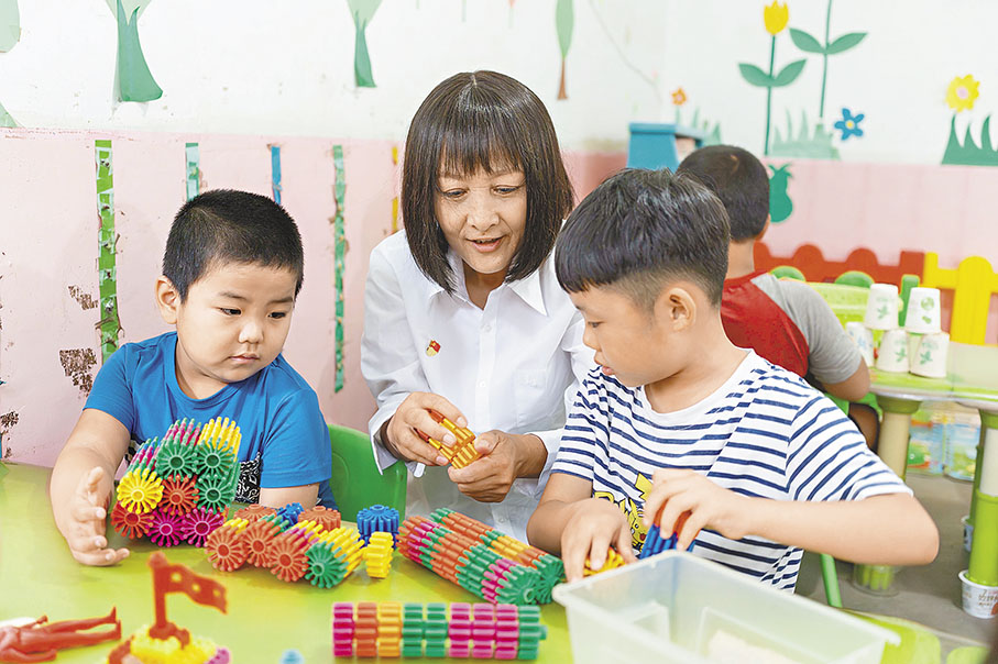 ●李霞與幼兒園的孩子們一起玩積木。 香港文匯報記者胡臥龍  攝