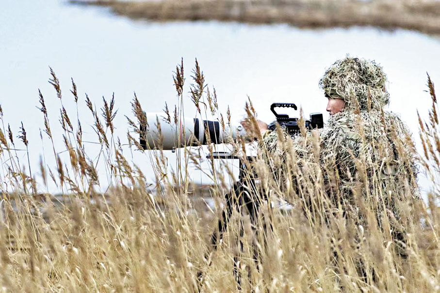 ●萬興富身穿「吉利服」蹲守拍攝。