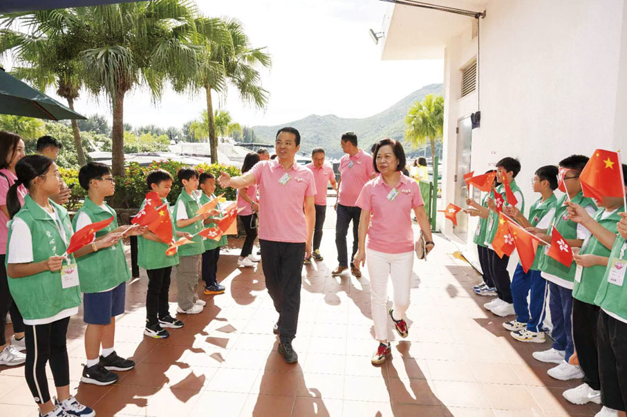 ●參加步行者揮舞國旗和區旗，祝小東和潘陳愛菁向大家揮手。