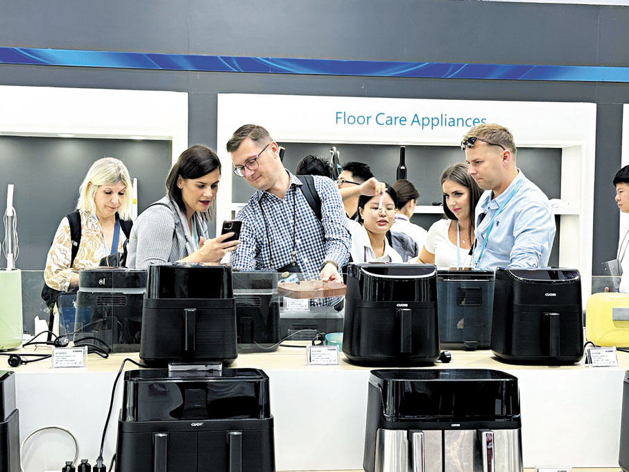 ●本屆廣交會一期以「先進製造」為主題，展出電子家電、工業製造、五金工具等五個板塊展品。圖為數名海外採購商在觀看中國製造的電飯煲家電產品，並拍下照片作參考。香港文匯報記者盧靜怡  攝