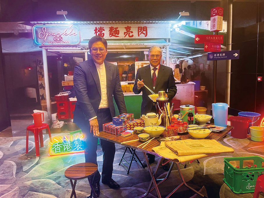 ●霍震霆（右）與霍啟剛合照於酒會內香港懷舊麵檔打卡角。