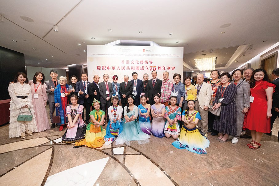 ●酒會發起人和一眾文化藝術界精英與穿着少數民族服飾的少女合照。