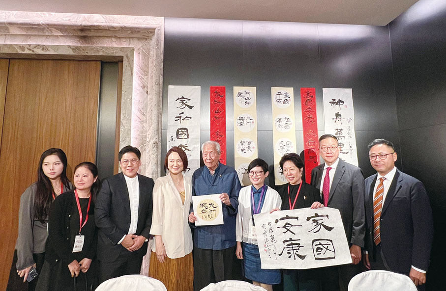 ●霍啟剛（左三）、李慧琼（左四）、施子清（左五)、陳雪儀（左六）、徐莉（左七）、施榮懷（左八）、葉傲冬（左九）與友好在酒會內的書法藝術體驗中合照。