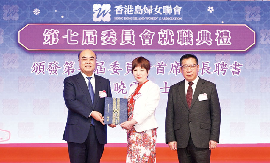 ●中央政府駐港聯絡辦港島工作部部長薛惠君（左）和全國政協委員蘇長荣（右）為香港島婦女聯會首席會長廖曉霞頒發聘書。