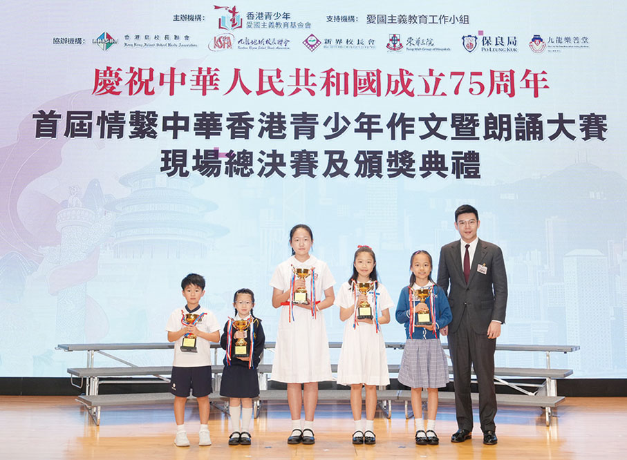 ●基金會常務副主席譚鎮國向小學組特等獎獲得者頒發獎盃。