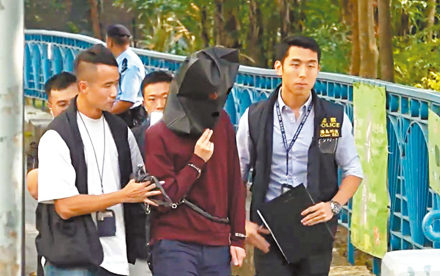 ●男疑犯昨日被黑布蒙頭，腰纏鐵鏈，由探員押解到瀑布灣公園重組案情。