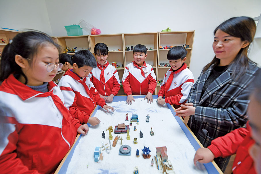 ●青少年心理健康工作是建設教育強國、健康中國的重要內容。圖為2022年3月，在嘉興市兒童青少年心理健康服務總站，學生們在老師的帶領下通過沙盤遊戲的方式進行心理分析。 （新華社）