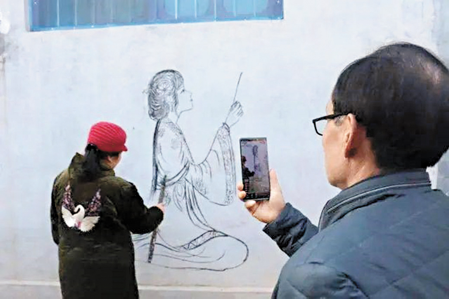 ●丁春梅在畫畫引來圍觀。香港文匯報山東傳真