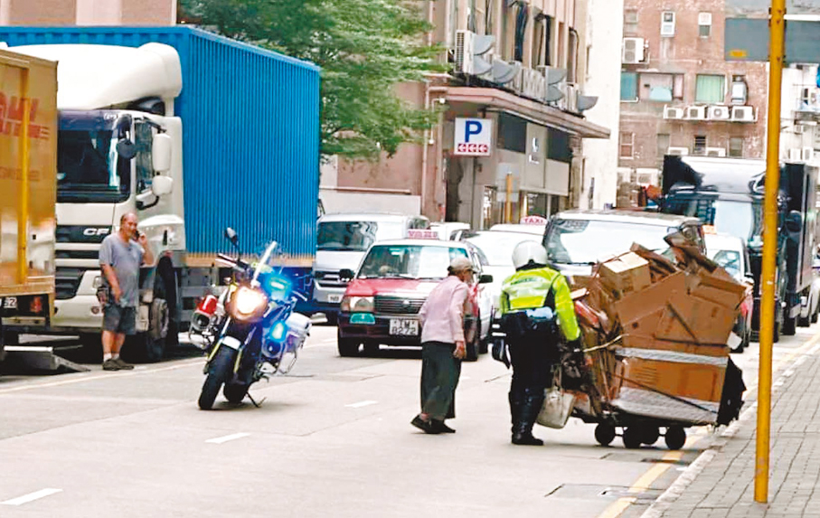 ●當日警員黃松燃在觀塘幫助執紙皮婆婆，被熱心市民拍下相片及向警務處致送讚揚信。