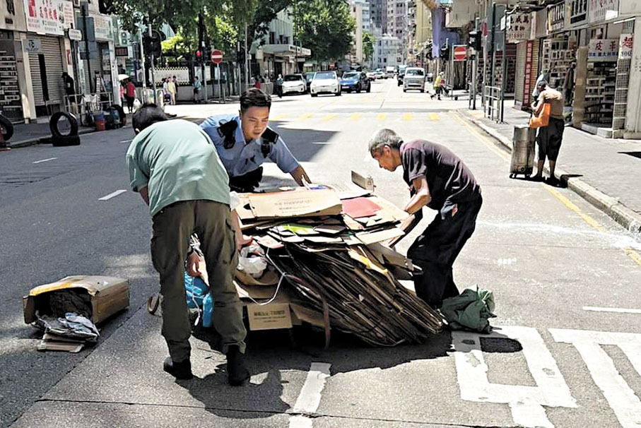 ●在警長王雅麟指揮下，警員李少華（穿制服）與便裝同袍落車幫助伯伯將紙皮執拾上手推車。 資料圖片