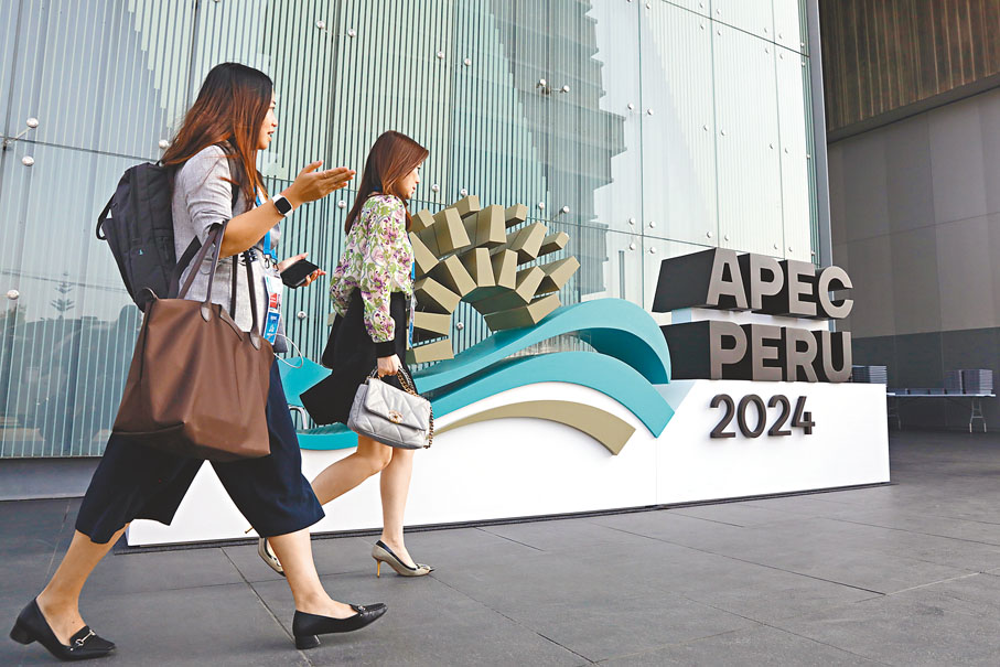 ●11月13日，人們從秘魯首都利馬會議中心外的2024年亞太經合組織會議標識前走過。亞太經合組織（APEC）第三十一次領導人非正式會議即將在秘魯首都利馬舉行。 新華社