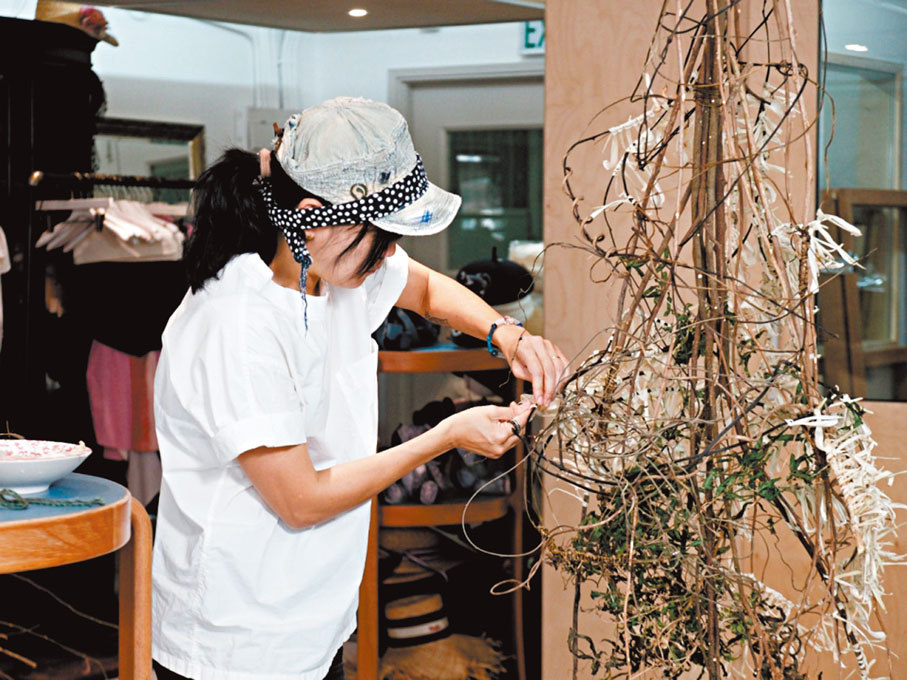 ●黃琪正在以薇甘菊作為線繩打結。