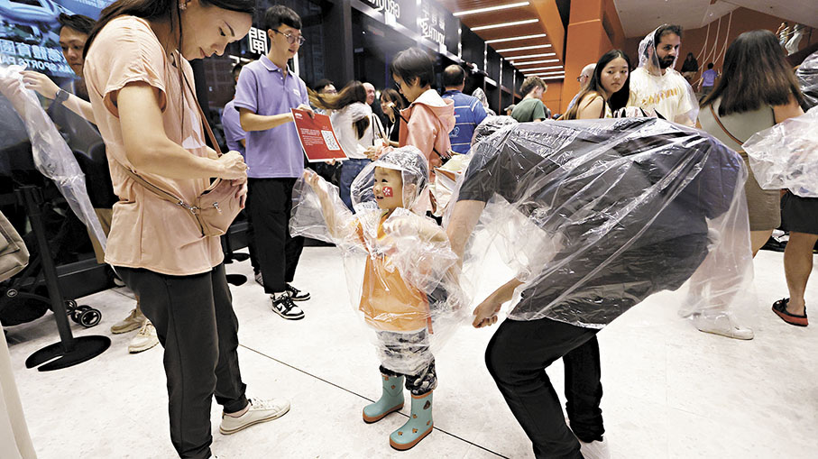 ●小朋友在大人協助下穿上雨衣。