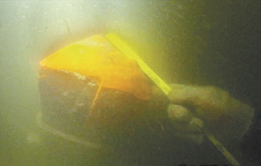 ●考古工作者在水下對經遠艦的船頭三角立柱進行測量。