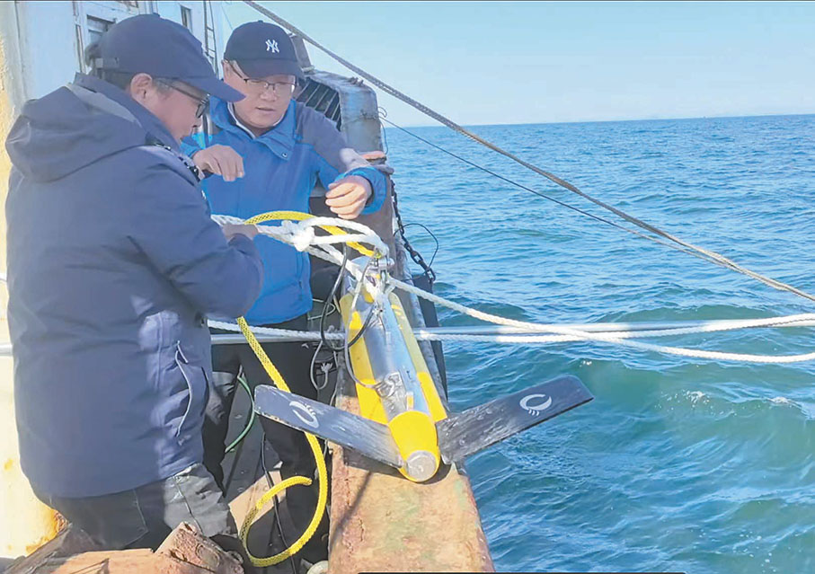 ●「四普」工作者準備將側掃聲納設備放入考察水域中。    于珈琳 攝