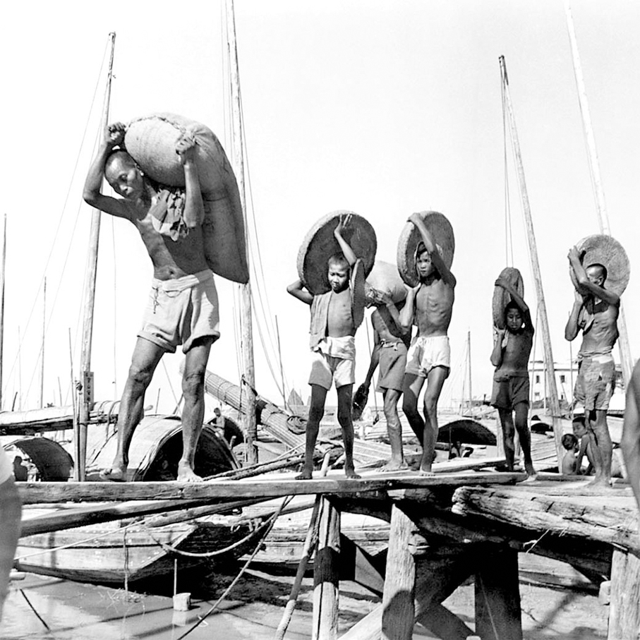 ●在碼頭工作的男人和男孩因長時間在戶外工作而曬得黝黑。   攝影師：海達·莫里森