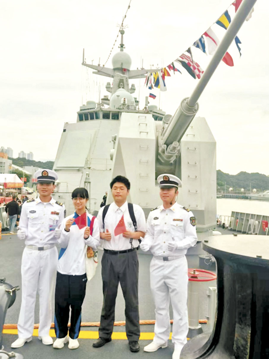 ●張凱晴（左二）和李文軒（左三）在艦上與官兵合照。 受訪者提供