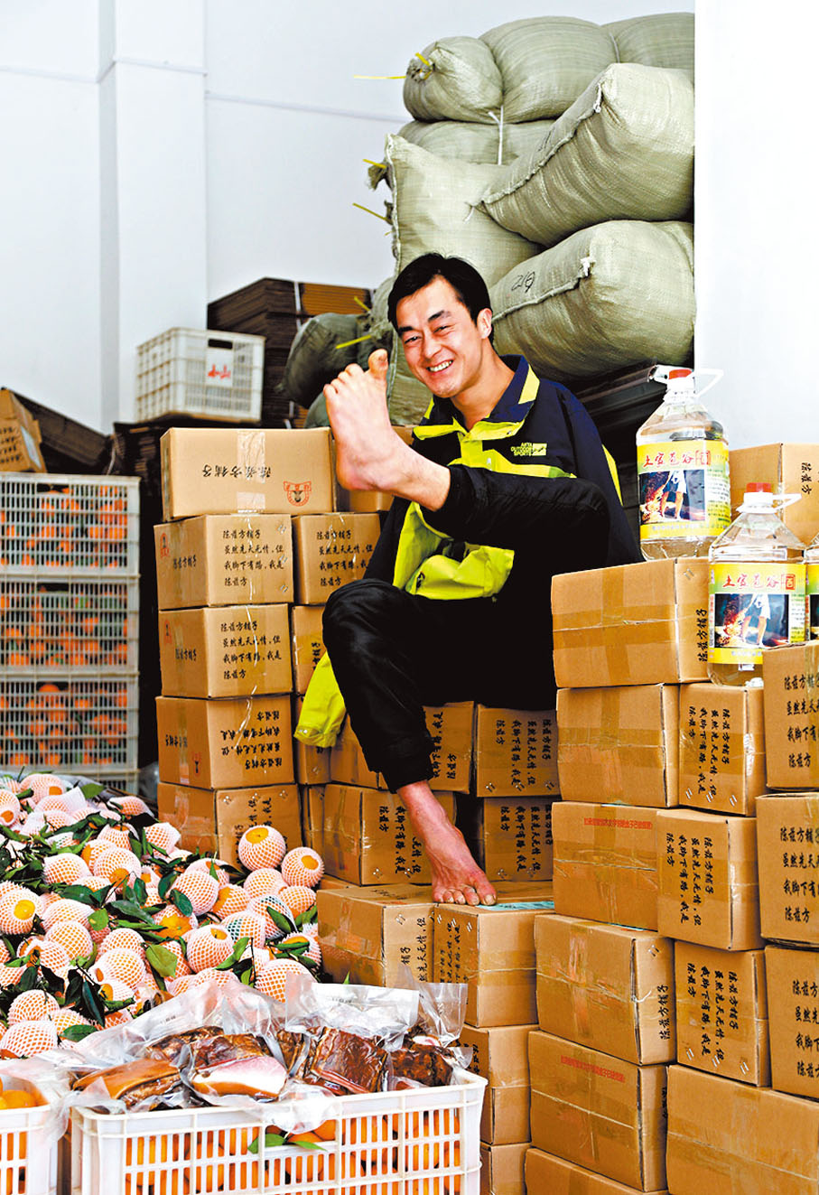 ●陳茲方店舖銷售的商品全部是他從農戶家親自採購、挑選的。圖為工作中的陳茲方。 香港文匯報武漢傳真