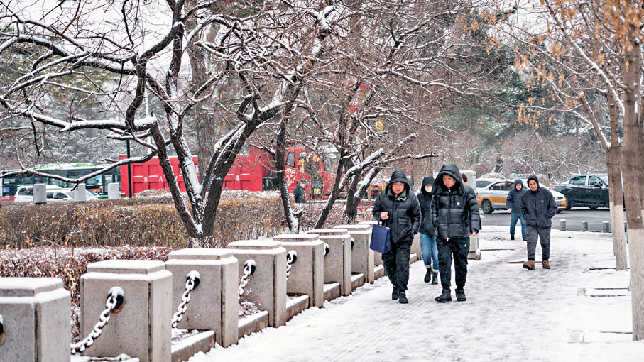 ●吉林省中西部出現大到暴雪，最大積雪深度已達100毫米。圖為市民行走在長春街頭。 新華社