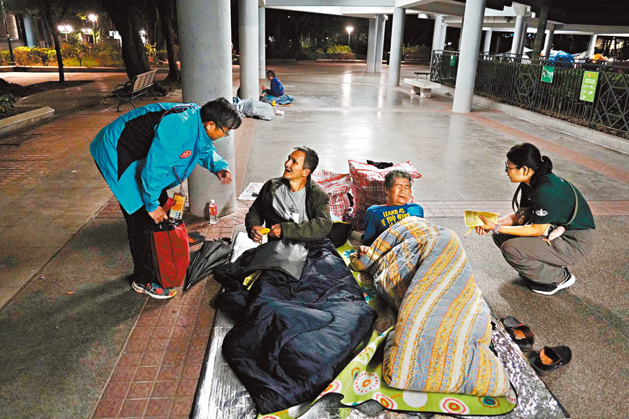 ●社協在大角咀送暖，不但向露宿者噓寒問暖，還派發香蕉、飲品及外套等物資。 香港文匯報記者曾興偉 攝