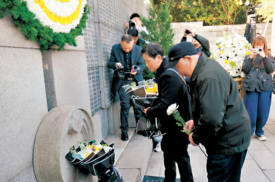 ●南京大屠殺倖存者劉民生老人和女兒向遇難親人和同胞獻花。 香港文匯報記者賀鵬飛  攝
