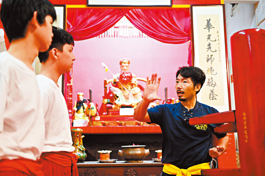 ●李健豪在鑾輿堂指導徒弟練習紅船木人樁。 中新社