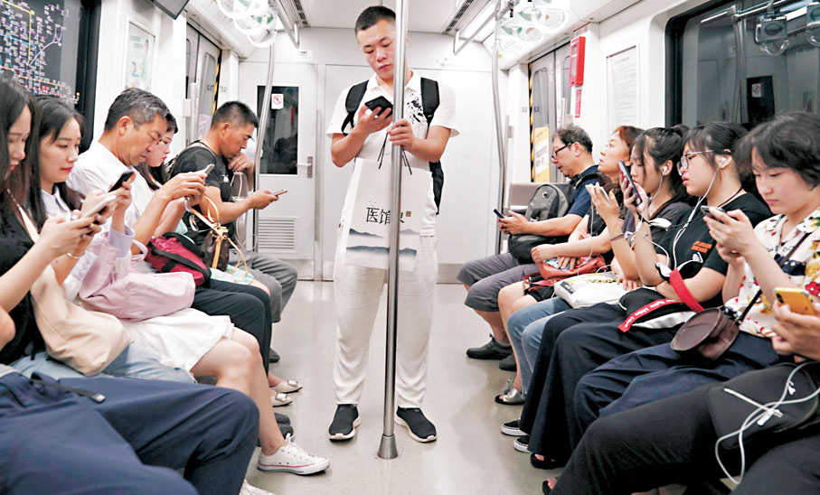 ●算法通過數據分析精準推送，潛移默化中影響用戶的認知與判斷。圖為市民在地鐵裏看手機。資料圖片