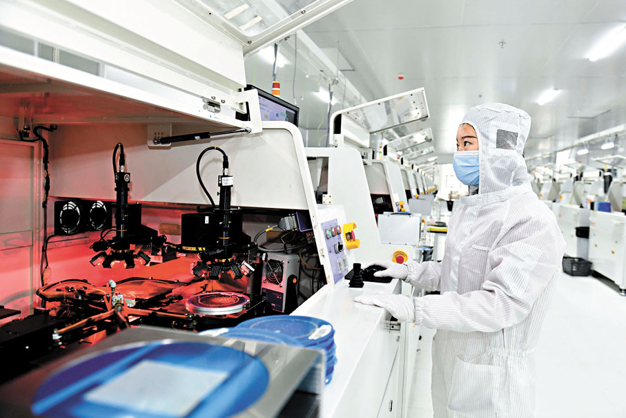 ●前11個月中國集成電路出口1.03萬億元，首次突破萬億元，同比增長20.3%。圖為在山東省巨野縣新一代信息技術產業園，工作人員在直顯芯片生產設備前值守。 資料圖片